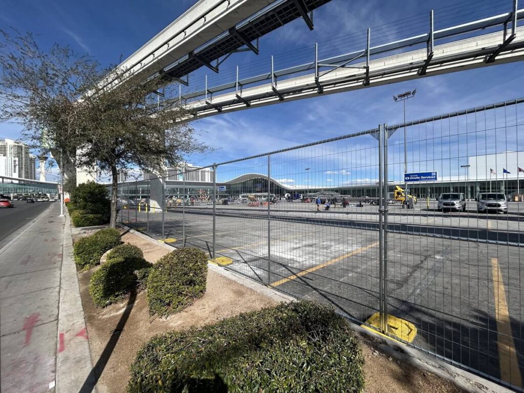 Instalación de una valla provisional de ZND a lo largo del terreno del centro de convenciones, bajo el monorraíl de Las Vegas